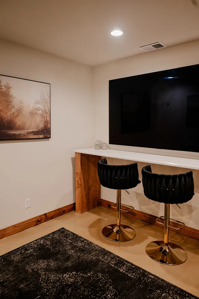 The Ember Suite — the lounge with its bar and TV wall