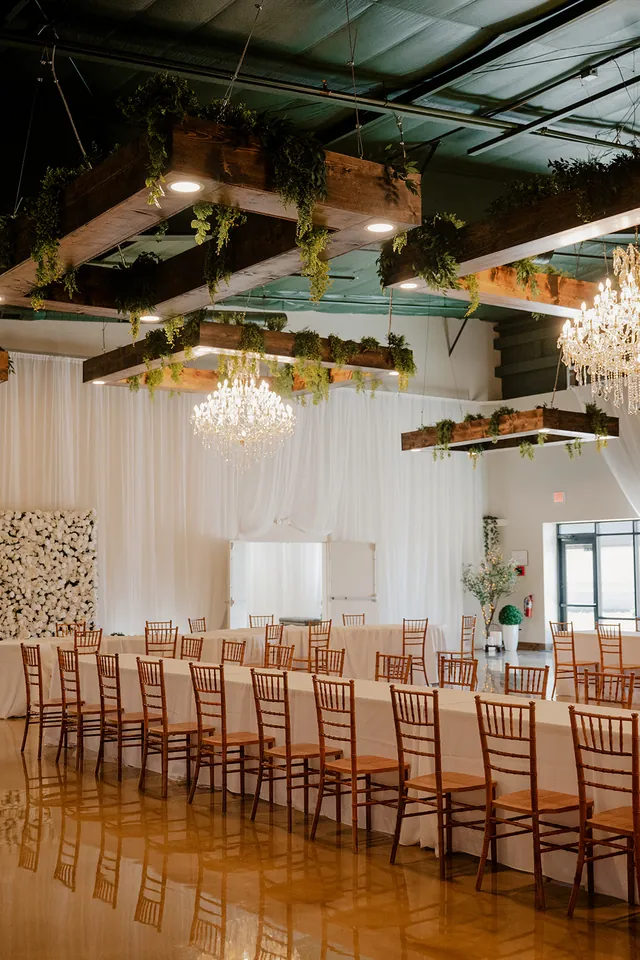 Solara Hall set for a long-table dinner under the greenery beams